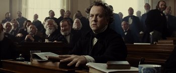 Movie still from “Lincoln” (2012), directed by Steven Spielberg – A man sitting in front of a group of people; Medium shot, Low angle