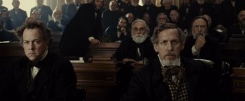 Movie still from “Lincoln” (2012), directed by Steven Spielberg – A group of men sitting next to each other in a courtroom; Medium shot, Over the shoulder angle