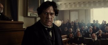 Movie still from “Lincoln” (2012), directed by Steven Spielberg – An old man in a court room with people in the background; Close Up shot, Over the shoulder angle