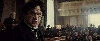 Movie still from “Lincoln” (2012), directed by Steven Spielberg – A man in a courtroom with people in the background; Close Up shot, Low angle