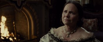 Movie still from “Lincoln” (2012), directed by Steven Spielberg – An older woman wearing a white dress and a gold necklace; Close Up shot, Over the shoulder angle