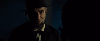 Movie still from “Lincoln” (2012), directed by Steven Spielberg – A man in a suit and a hat standing in front of a wall; Close Up shot, Over the shoulder angle