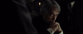 Movie still from “Lincoln” (2012), directed by Steven Spielberg – An older man in a black suit and white shirt is holding his hands to his face; Close Up shot, Over the shoulder angle