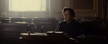 Movie still from “Lincoln” (2012), directed by Steven Spielberg – An older man sitting at a desk in a room; Medium shot, Over the shoulder angle