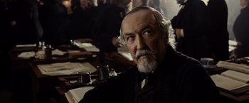 Movie still from “Lincoln” (2012), directed by Steven Spielberg – An old man with a beard sitting at a table; Close Up shot, Over the shoulder angle