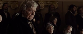 Movie still from “Lincoln” (2012), directed by Steven Spielberg – An old man and a group of people in a room; Close Up shot, Over the shoulder angle