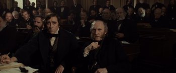 Movie still from “Lincoln” (2012), directed by Steven Spielberg – A group of men in suits and ties sitting in front of a crowd; Medium shot, Low angle