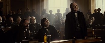 Movie still from “Lincoln” (2012), directed by Steven Spielberg – A man in a courtroom with other people; Medium shot, Over the shoulder angle