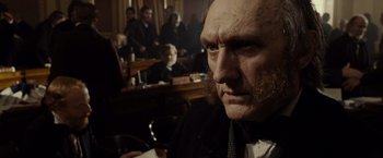 Movie still from “Lincoln” (2012), directed by Steven Spielberg – An old man with a beard and mustache in a dark room; Close Up shot, Over the shoulder angle