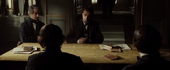 Movie still from “Lincoln” (2012), directed by Steven Spielberg – A man sitting at a table in front of another man; Medium shot, Over the shoulder angle