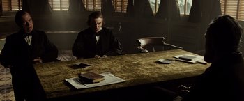 Movie still from “Lincoln” (2012), directed by Steven Spielberg – A man sitting at a table in a room; Medium shot, Over the shoulder angle