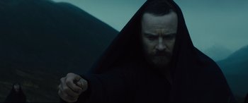 Movie still from “Macbeth” (2015), directed by Justin Kurzel – A man in a black robe holding a knife; Medium shot, Low angle
