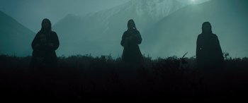Movie still from “Macbeth” (2015), directed by Justin Kurzel – A person standing in a field near a mountain; Extreme Wide shot, Low angle