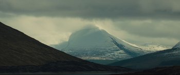 Movie still from “Macbeth” (2015), directed by Justin Kurzel – A mountain with snow on it's side and a cloudy sky above it; Extreme Wide shot, Low angle