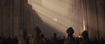 Movie still from “Macbeth” (2015), directed by Justin Kurzel – A group of people standing in front of a building; Extreme Wide shot, Low angle