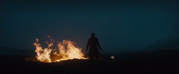Movie still from “Macbeth” (2015), directed by Justin Kurzel – A man standing in front of a fire at night; Wide shot, Low angle