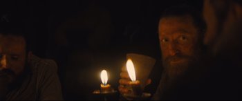 Movie still from “Macbeth” (2015), directed by Justin Kurzel – A man holding a candle in front of a dark background; Close Up shot, Low angle