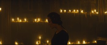 Movie still from “Macbeth” (2015), directed by Justin Kurzel – A woman standing in front of a bunch of lit candles; Medium shot, Low angle