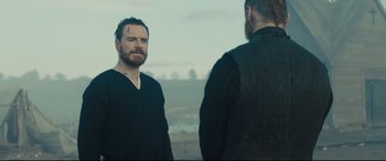 Movie still from “Macbeth” (2015), directed by Justin Kurzel – Two men standing next to each other on a field; Medium shot, Over the shoulder angle