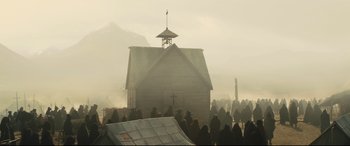 Movie still from “Macbeth” (2015), directed by Justin Kurzel – A group of people standing around a church in the middle of the fog; Extreme Wide shot, Low angle
