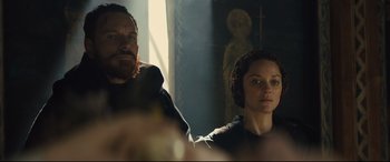 Movie still from “Macbeth” (2015), directed by Justin Kurzel – A man and a woman standing next to each other in a room; Medium shot, Over the shoulder angle