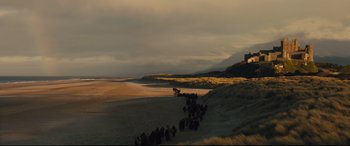 Movie still from “Macbeth” (2015), directed by Justin Kurzel – A group of people walking on a beach near the ocean; Extreme Wide shot, Low angle