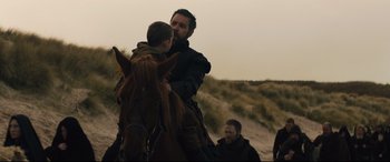 Movie still from “Macbeth” (2015), directed by Justin Kurzel – A man riding a horse with a child on the back of it; Medium shot, Over the shoulder angle