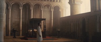 Movie still from “Macbeth” (2015), directed by Justin Kurzel – A man standing in front of a bed inside of a building; Wide shot, Low angle