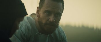 Movie still from “Macbeth” (2015), directed by Justin Kurzel – A person with a beard looking at the camera; Close Up shot, Over the shoulder angle