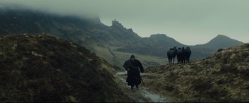 Movie still from “Macbeth” (2015), directed by Justin Kurzel – A man walking through a field with two horses; Extreme Wide shot, Over the shoulder angle