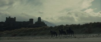 Movie still from “Macbeth” (2015), directed by Justin Kurzel – A group of people riding horses on a beach; Extreme Wide shot, Low angle