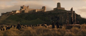 Movie still from “Macbeth” (2015), directed by Justin Kurzel – A group of people standing on top of a grass covered field; Extreme Wide shot, High angle