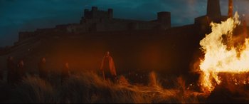 Movie still from “Macbeth” (2015), directed by Justin Kurzel – A man standing in a field at night with a castle in the background; Extreme Wide shot, High angle