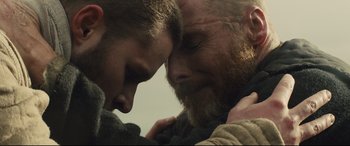 Movie still from “Macbeth” (2015), directed by Justin Kurzel – A man with a beard is hugging another man's face; Close Up shot, Low angle