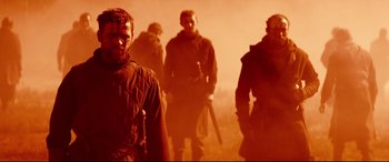 Movie still from “Macbeth” (2015), directed by Justin Kurzel – A group of men walking through a field; Medium shot, Low angle
