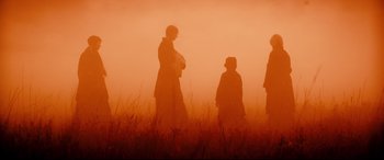 Movie still from “Macbeth” (2015), directed by Justin Kurzel – A group of people walking through a field; Wide shot, Over the shoulder angle