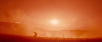 Movie still from “Macbeth” (2015), directed by Justin Kurzel – A person sitting in a field in the middle of the day; Extreme Wide shot, Low angle