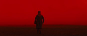 Movie still from “Macbeth” (2015), directed by Justin Kurzel – A person walking in a field in front of a red sky; Wide shot, Low angle