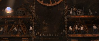 Movie still from “Mad Max: Fury Road” (2015), directed by George Miller – A group of people standing under a large clock; Extreme Wide shot, High angle