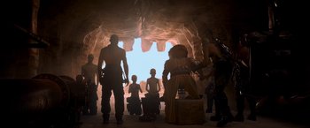 Movie still from “Mad Max: Fury Road” (2015), directed by George Miller – A group of people standing inside of a cave; Wide shot, Low angle