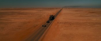 Movie still from “Mad Max: Fury Road” (2015), directed by George Miller – Two motorcycles are driving down a dirt road; Extreme Wide shot, High angle