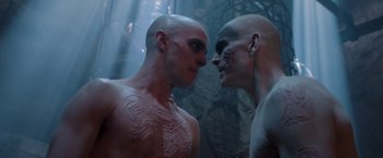 Movie still from “Mad Max: Fury Road” (2015), directed by George Miller – Two men are face to face in a dark room; Close Up shot, Over the shoulder angle