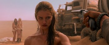 Movie still from “Mad Max: Fury Road” (2015), directed by George Miller – A woman with wet hair standing in front of a dump truck; Close Up shot, Low angle