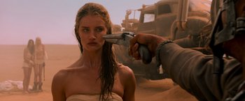 Movie still from “Mad Max: Fury Road” (2015), directed by George Miller – A woman is being shaved by a man in the desert; Close Up shot, Over the shoulder angle