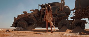 Movie still from “Mad Max: Fury Road” (2015), directed by George Miller – A woman standing in front of an off road vehicle; Wide shot, Low angle