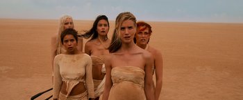 Movie still from “Mad Max: Fury Road” (2015), directed by George Miller – A group of women standing next to each other in the desert; Medium shot, High angle