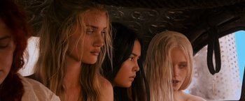 Movie still from “Mad Max: Fury Road” (2015), directed by George Miller – A group of three women standing next to each other; Close Up shot, Low angle
