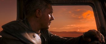 Movie still from “Mad Max: Fury Road” (2015), directed by George Miller – A person in a car looking out the window; Close Up shot, Over the shoulder angle