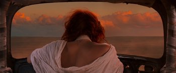 Movie still from “Mad Max: Fury Road” (2015), directed by George Miller – A woman sitting in a car looking out at the ocean; Medium shot, Low angle