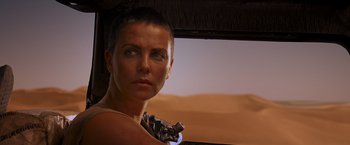 Movie still from “Mad Max: Fury Road” (2015), directed by George Miller – A person wearing a neck tie; Close Up shot, Over the shoulder angle